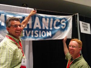 Chris Papadopoulos and Brianno Coller hanging the Mechanics Division banner.